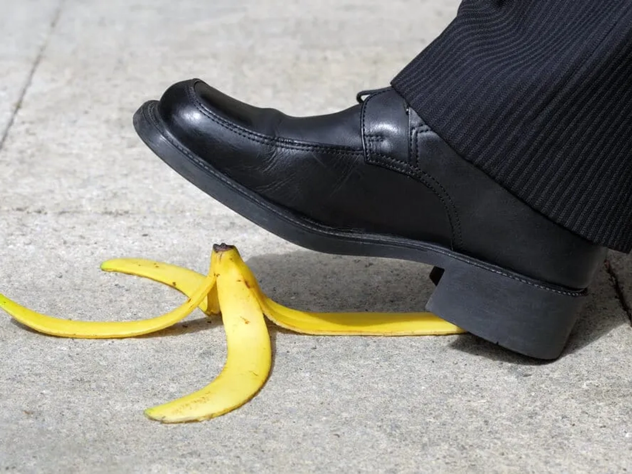 casca de banana no chao e sapato preto a pisá-la