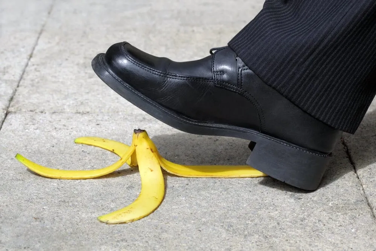 casca de banana no chao e sapato preto a pisá-la