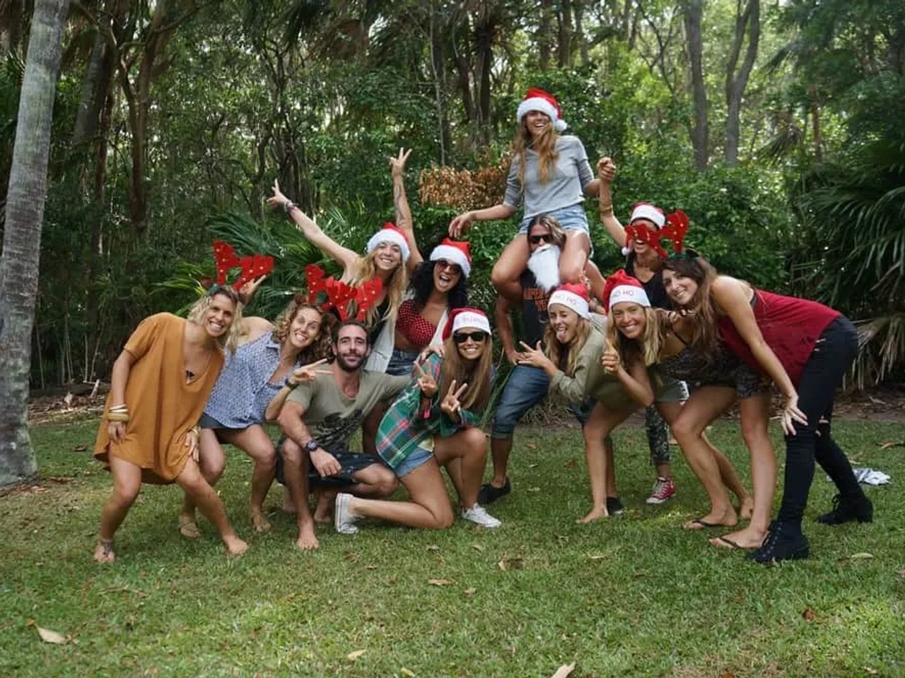 Grupo de amigos celebrando con gorros navideños en un entorno natural.