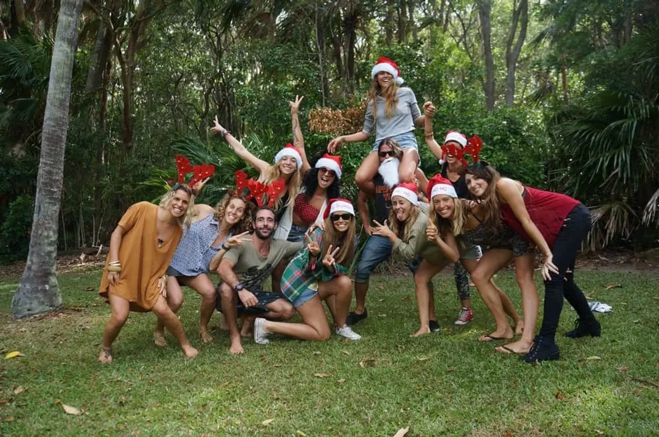 Grupo de amigos celebrando con gorros navideños en un entorno natural.