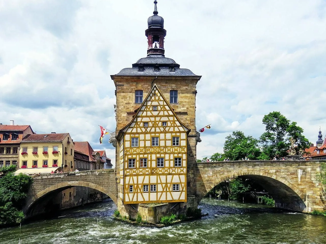 Casa histórica em uma ponte sobre um rio, cercada por arquitetura alemã.