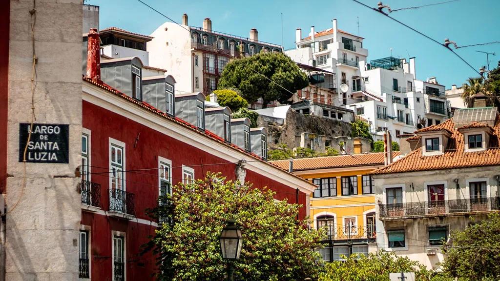 Vista do Largo de Santa Luzia, com casas coloridas e vegetação ao fundo.