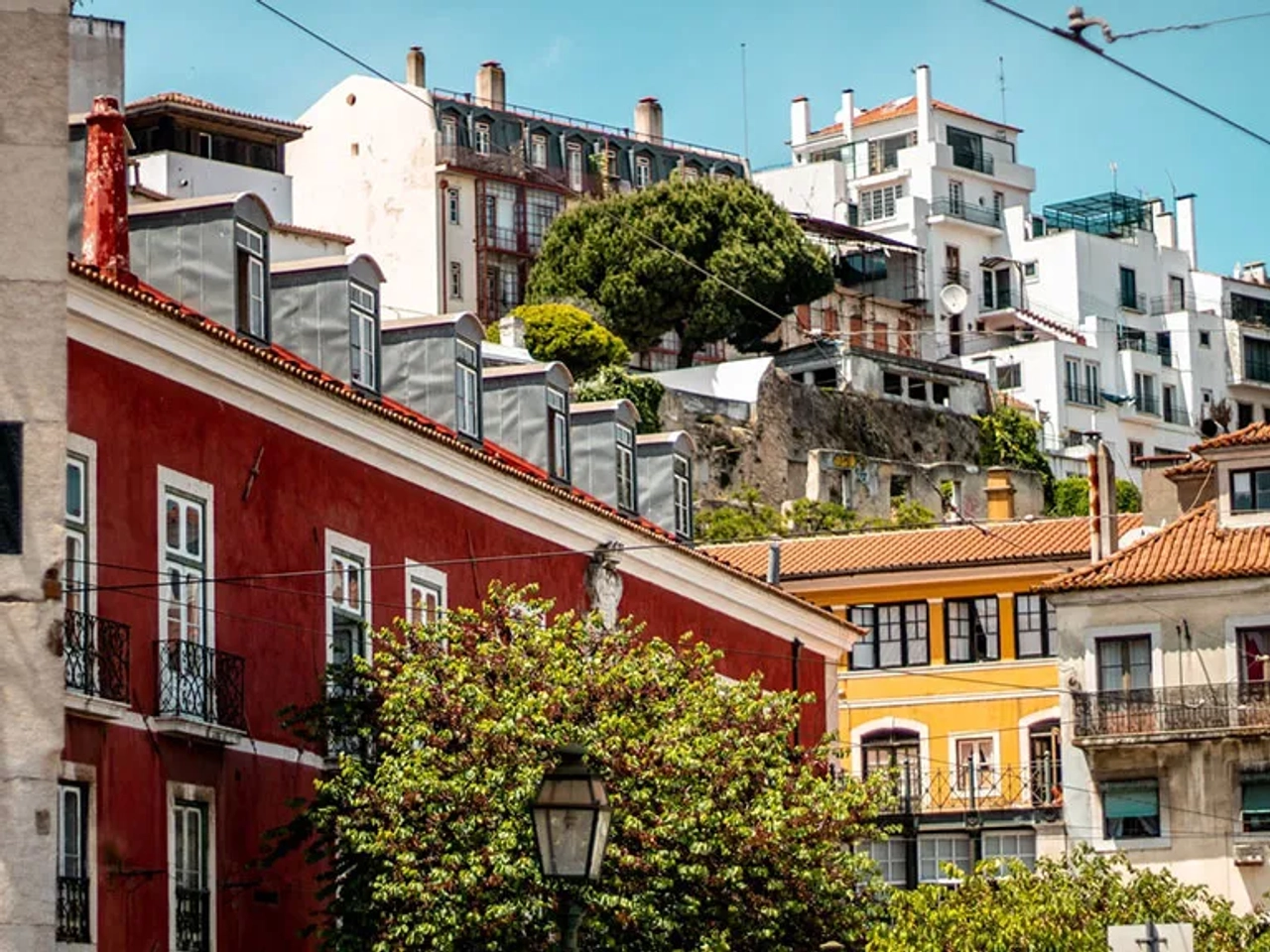 Vista do Largo de Santa Luzia, com casas coloridas e vegetação ao fundo.
