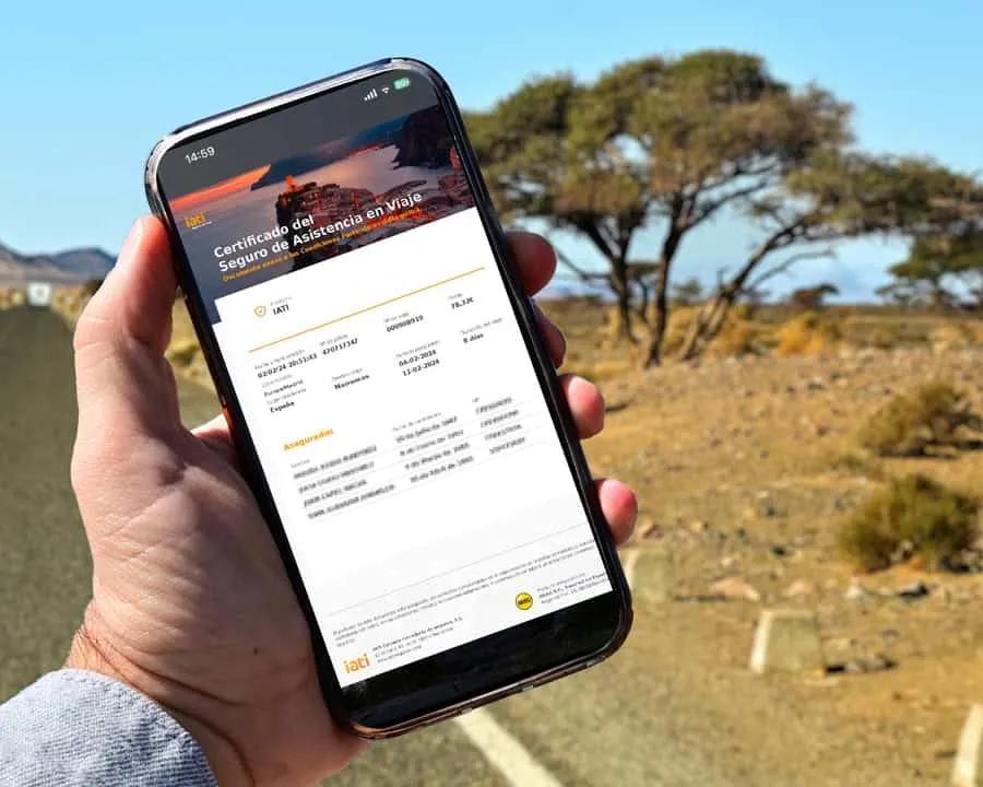 Certificado de seguro de asistencia en viaje mostrado en un teléfono móvil.