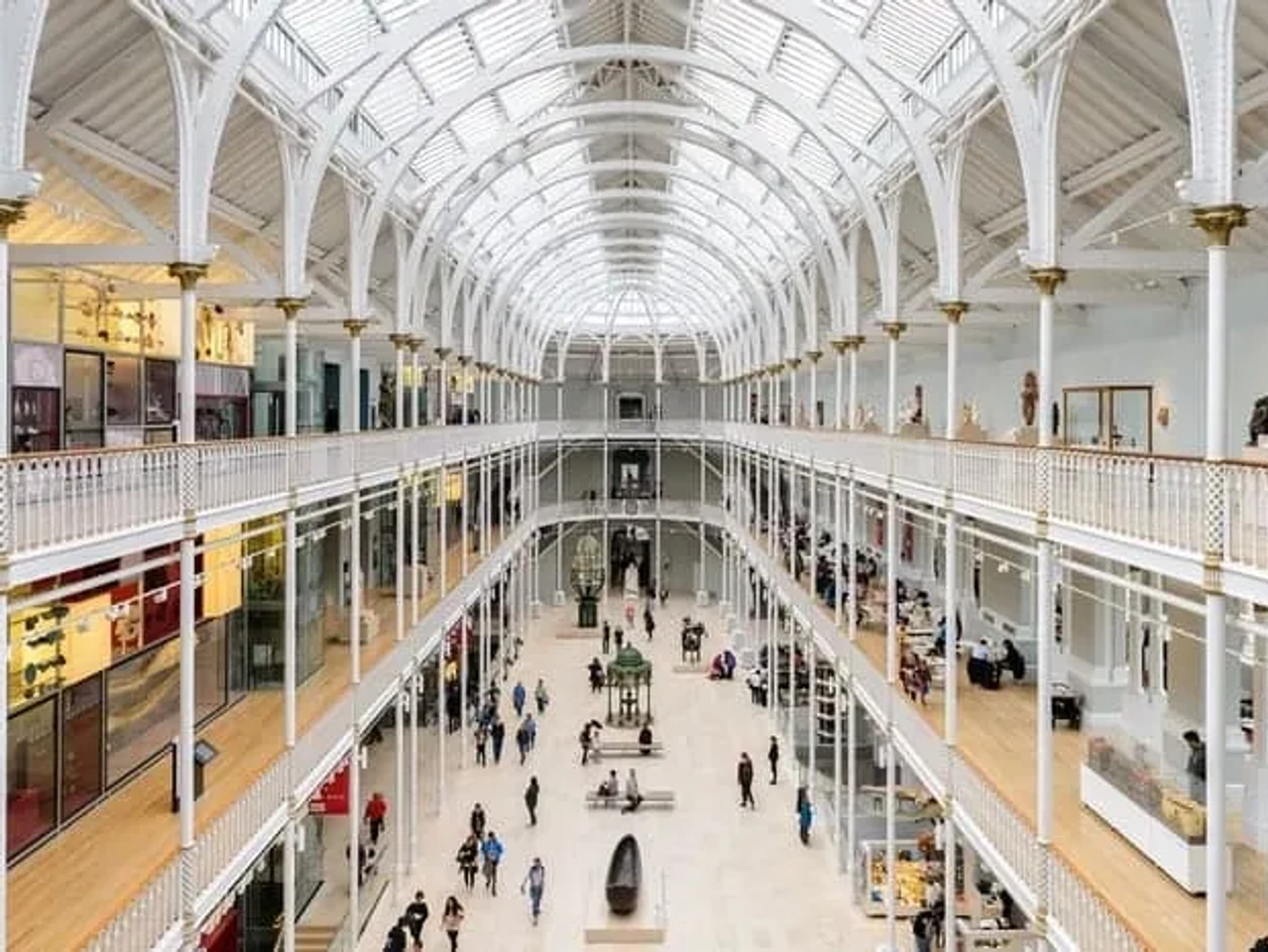 Interior do Museu Nacional da Escócia, com visitantes e exposições em destaque.