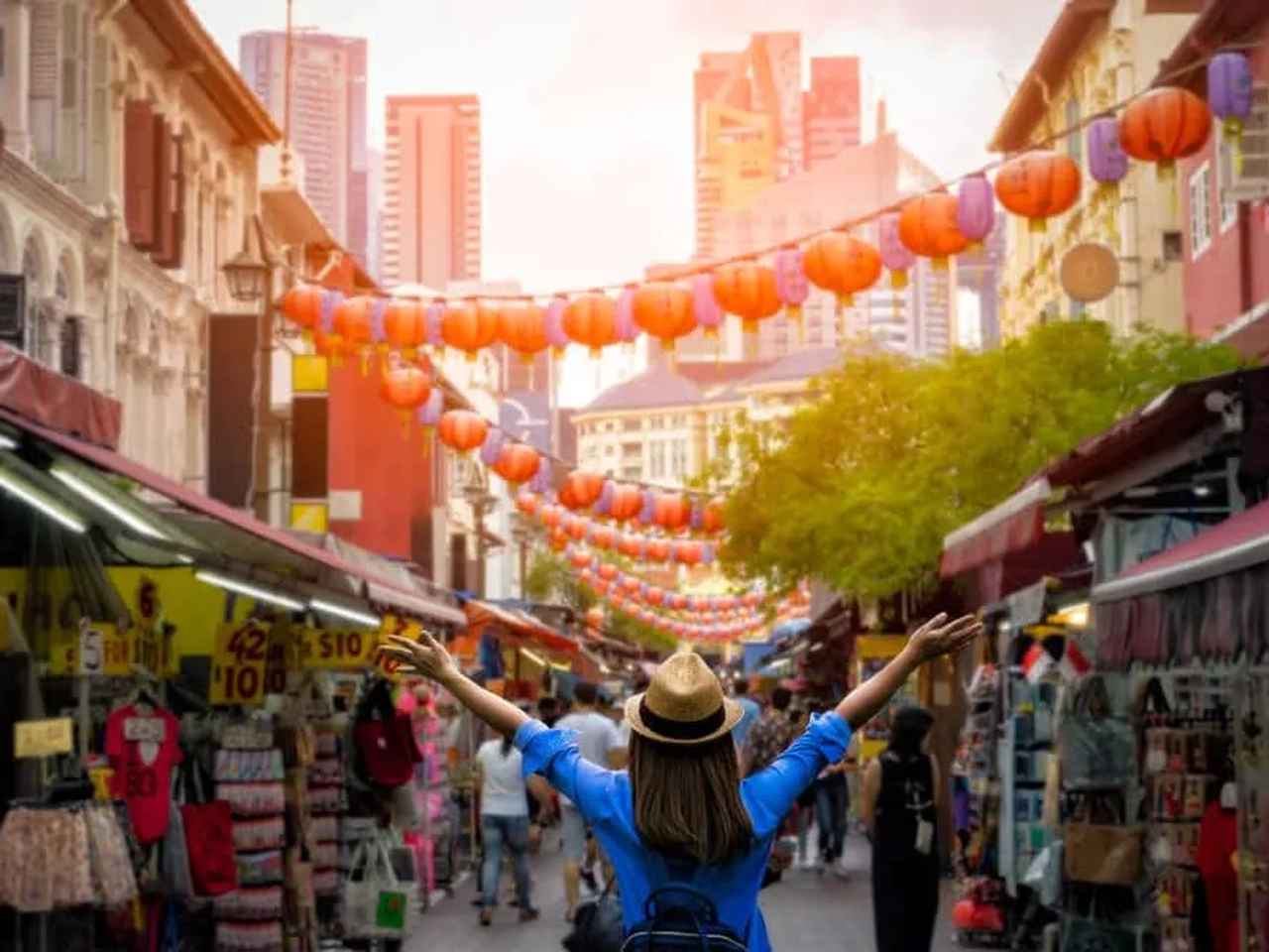 mulher de braços abertos no meio de chinatown