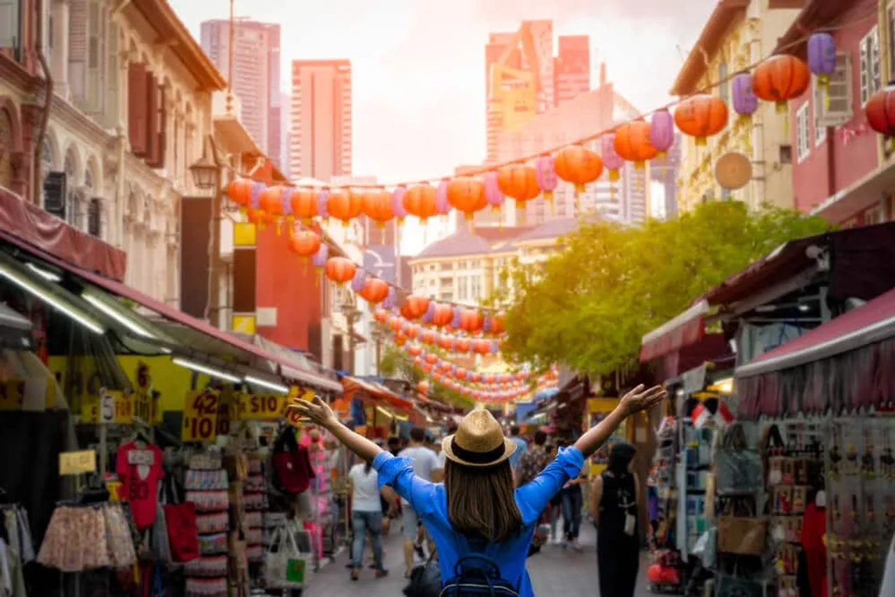 mulher de braços abertos no meio de chinatown