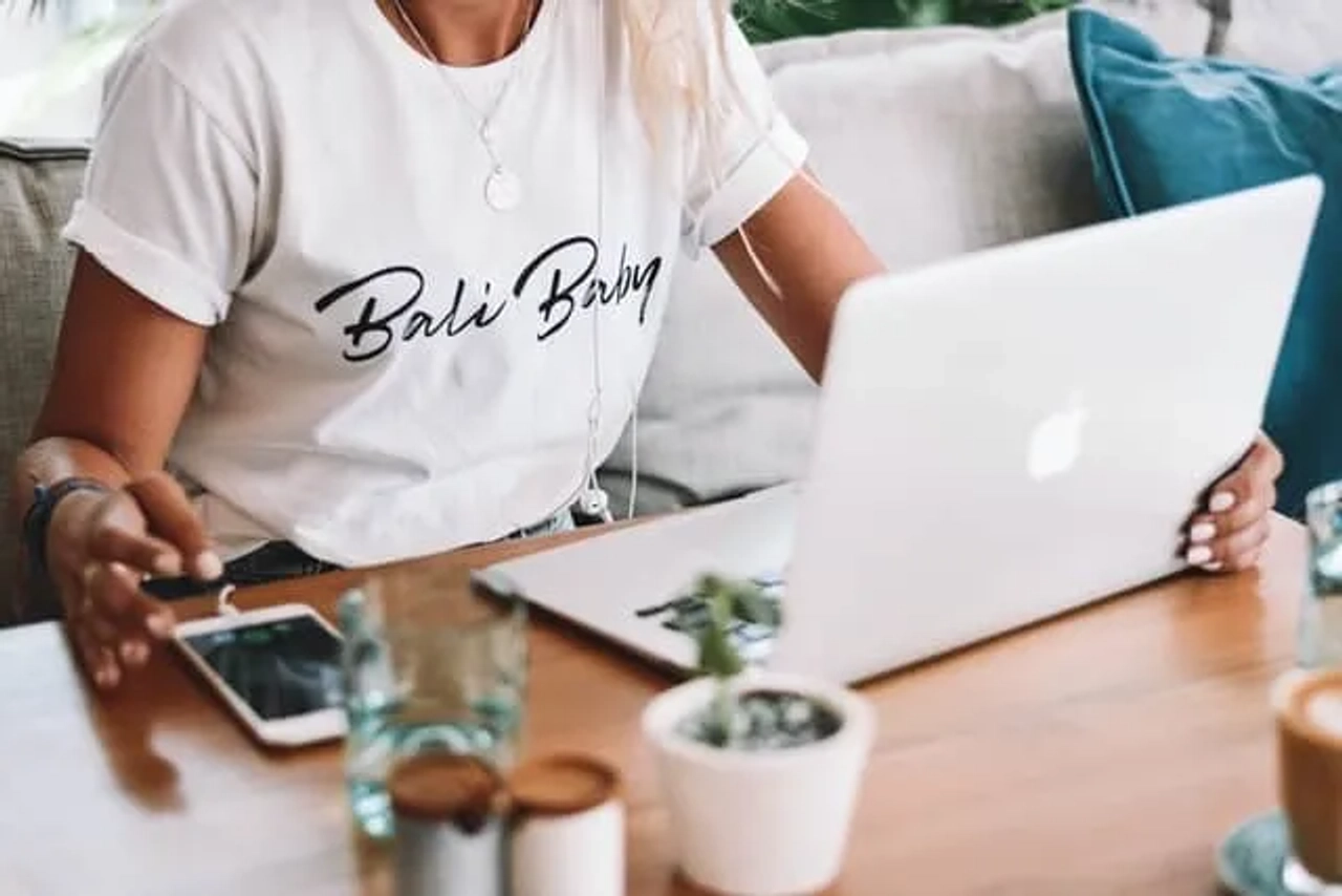rapariga a trabalhar numa secretária com macbook e tshirt de bali