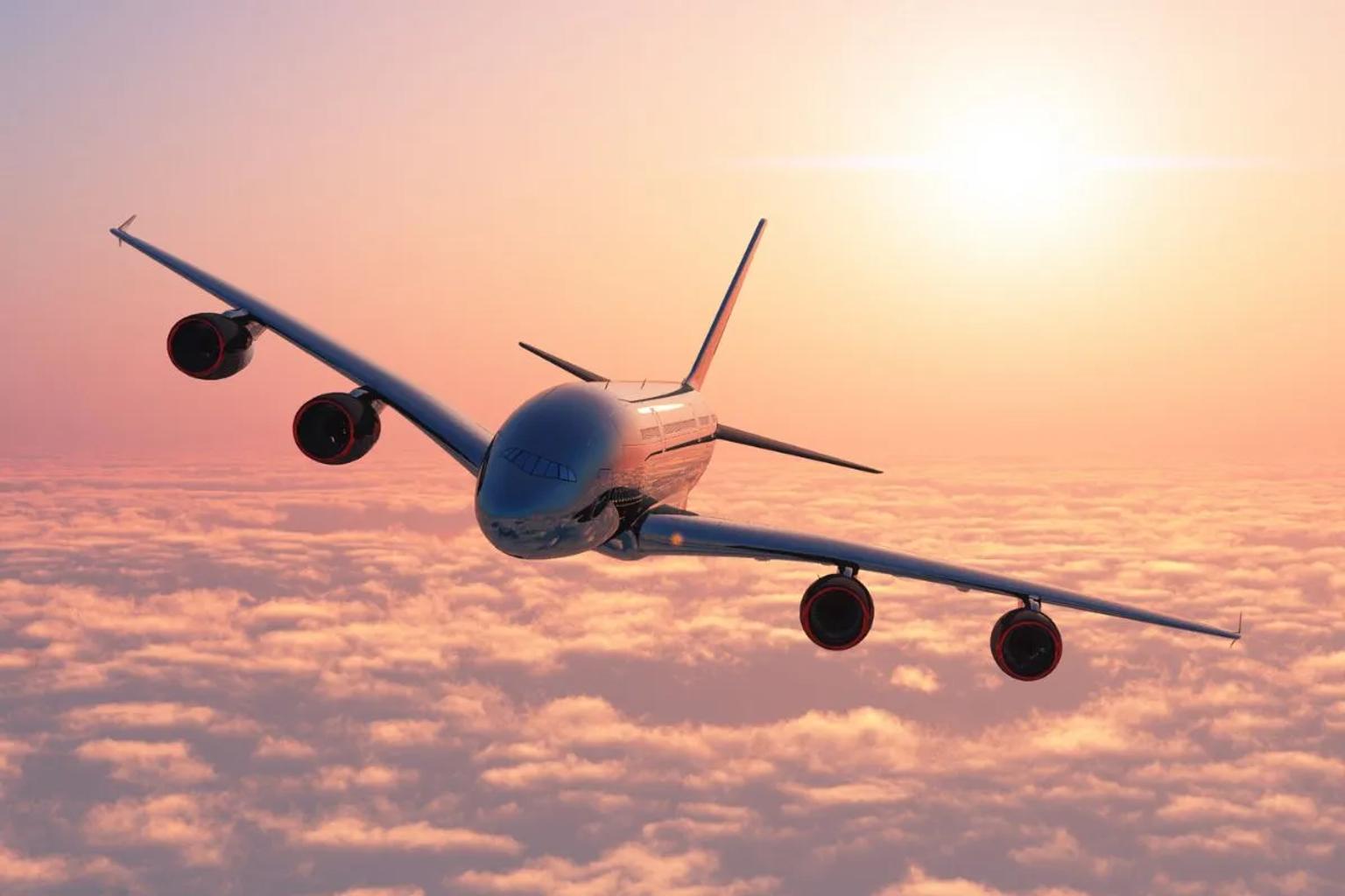 Avión volando sobre nubes al atardecer, simbolizando viajes y aventuras.