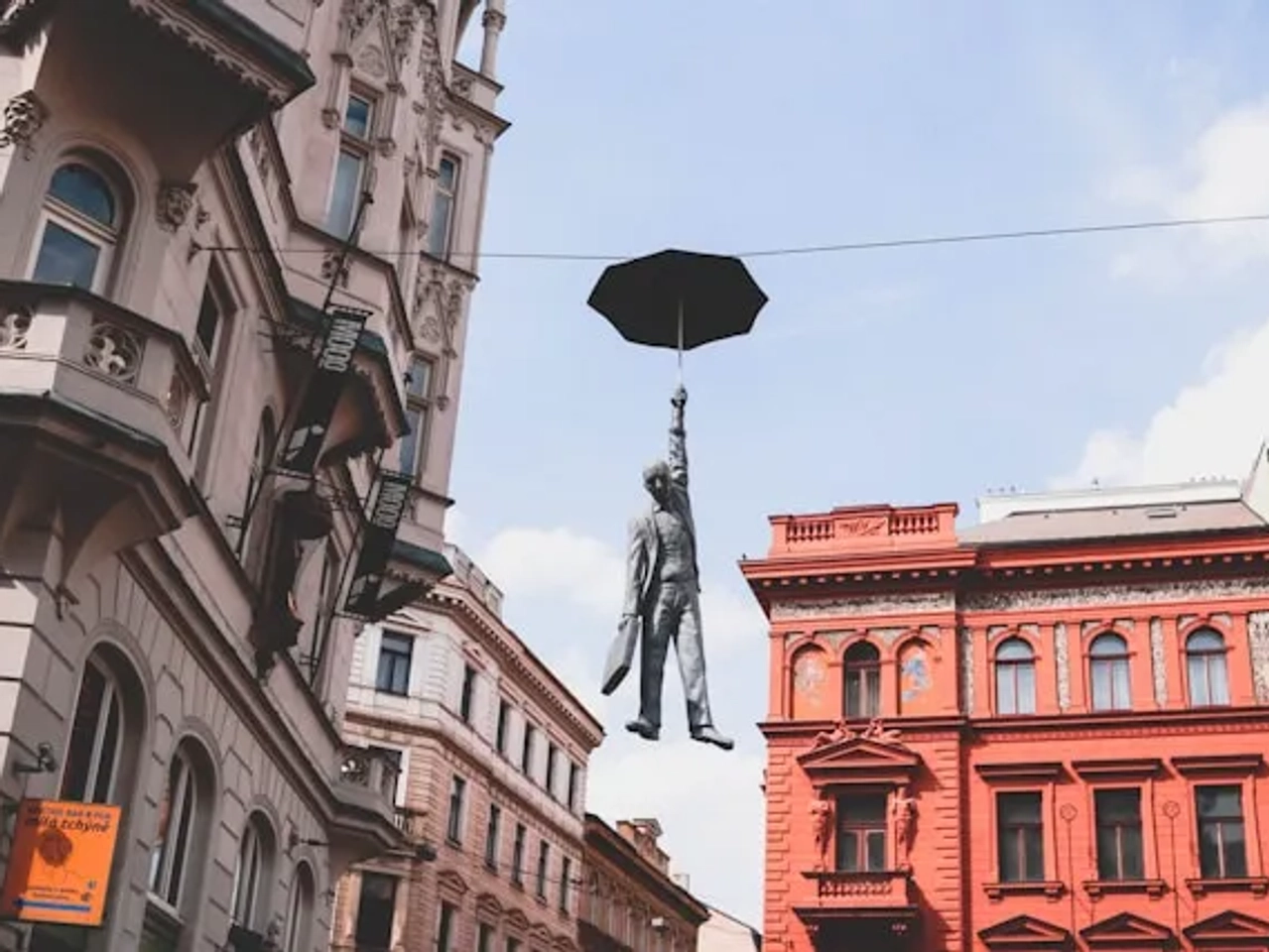 estatua de um homem a segurar um guarda chuva em praga