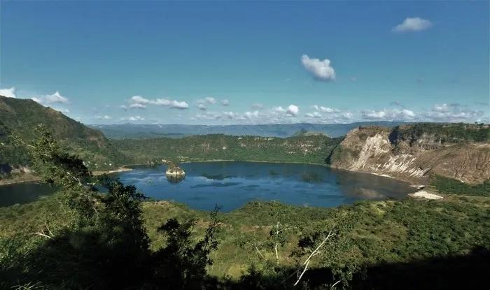 Vista panorámica de un lago rodeado de montañas y vegetación.
