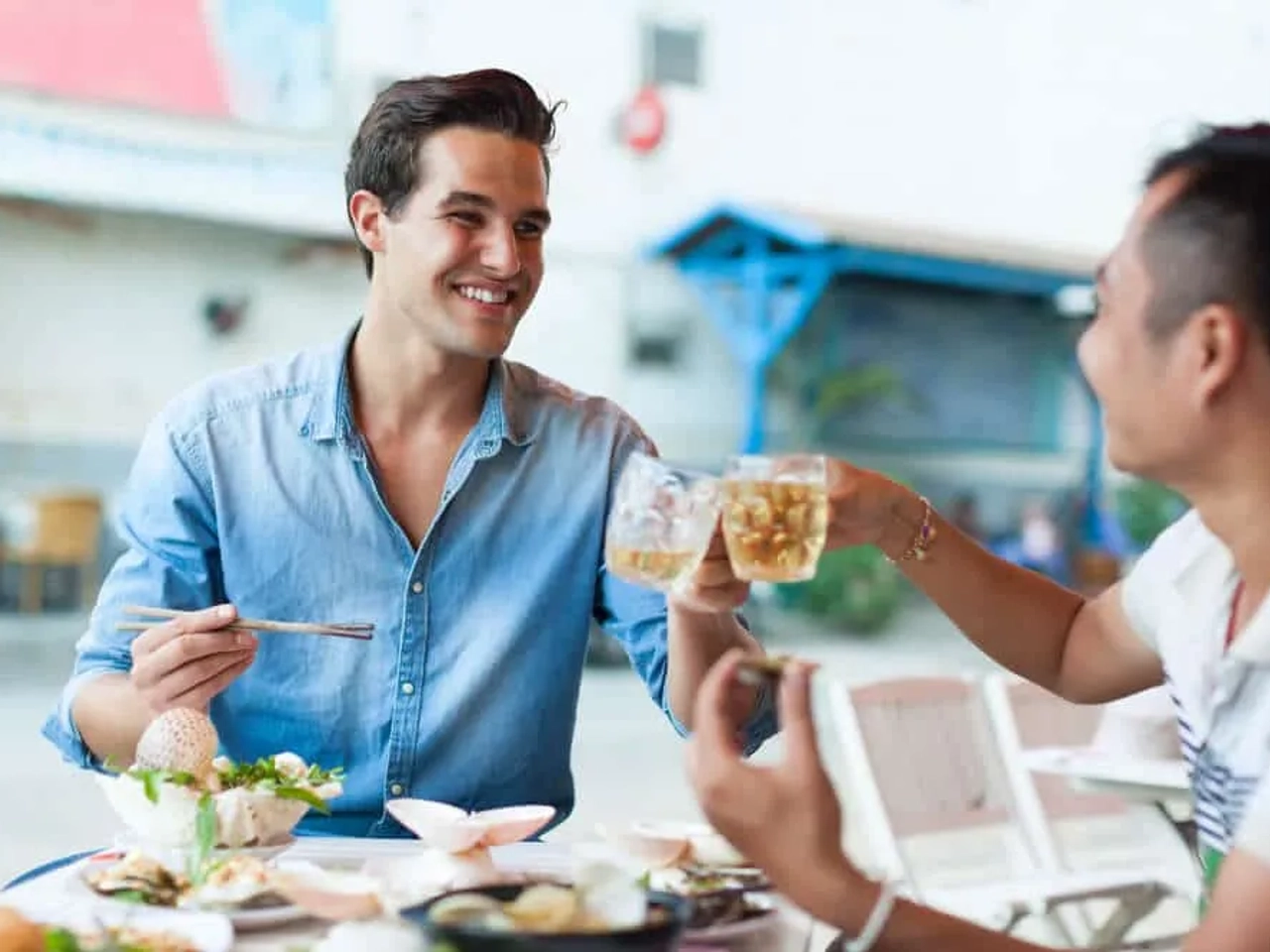 rapaz come comida local com um nativo