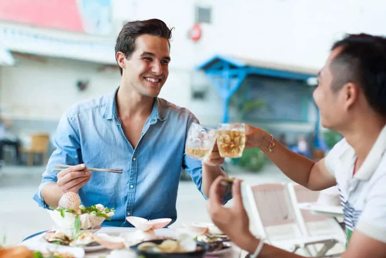 rapaz come comida local com um nativo