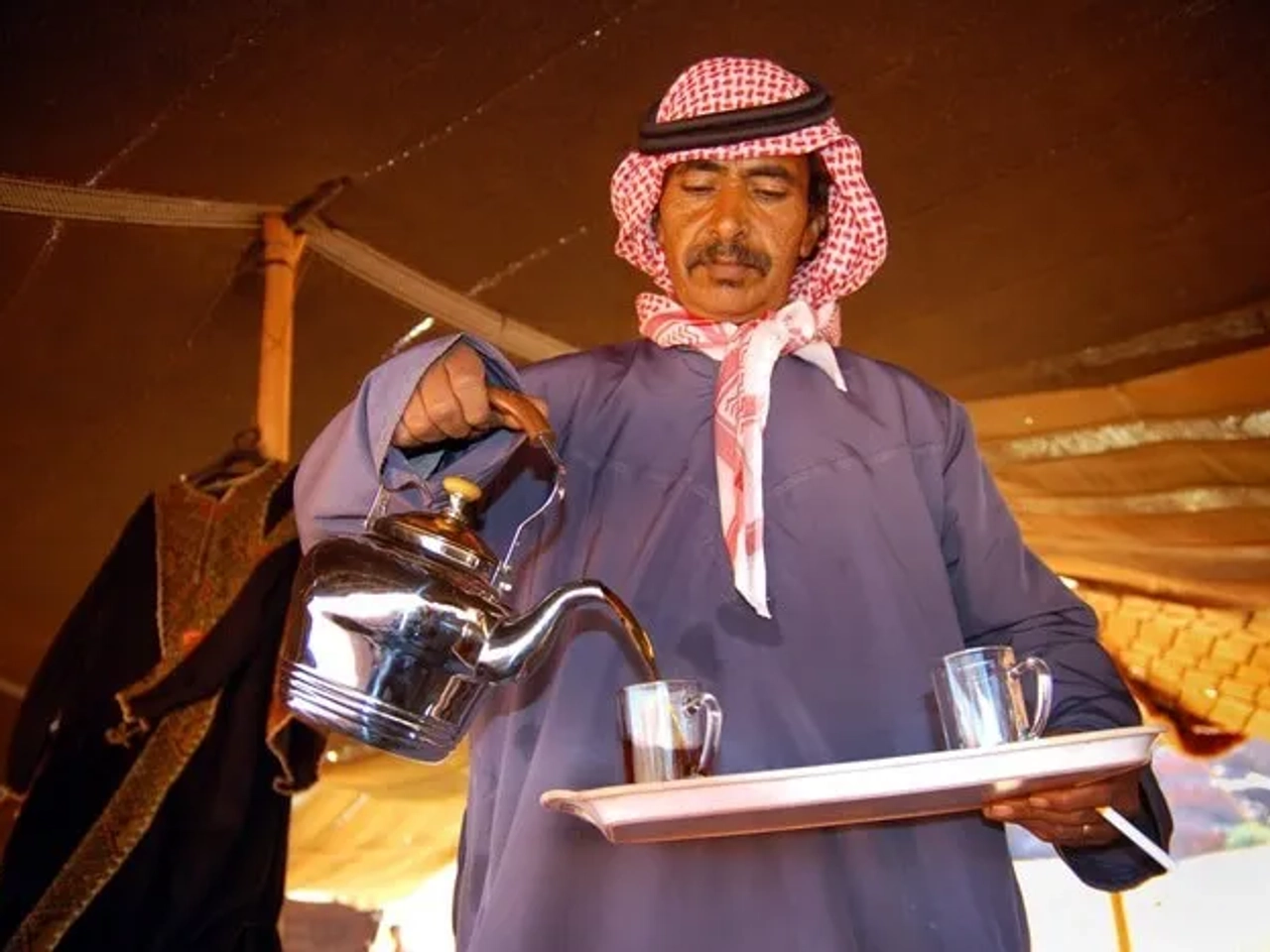 Hombre sirviendo té en un entorno tradicional beduino en Jordania.