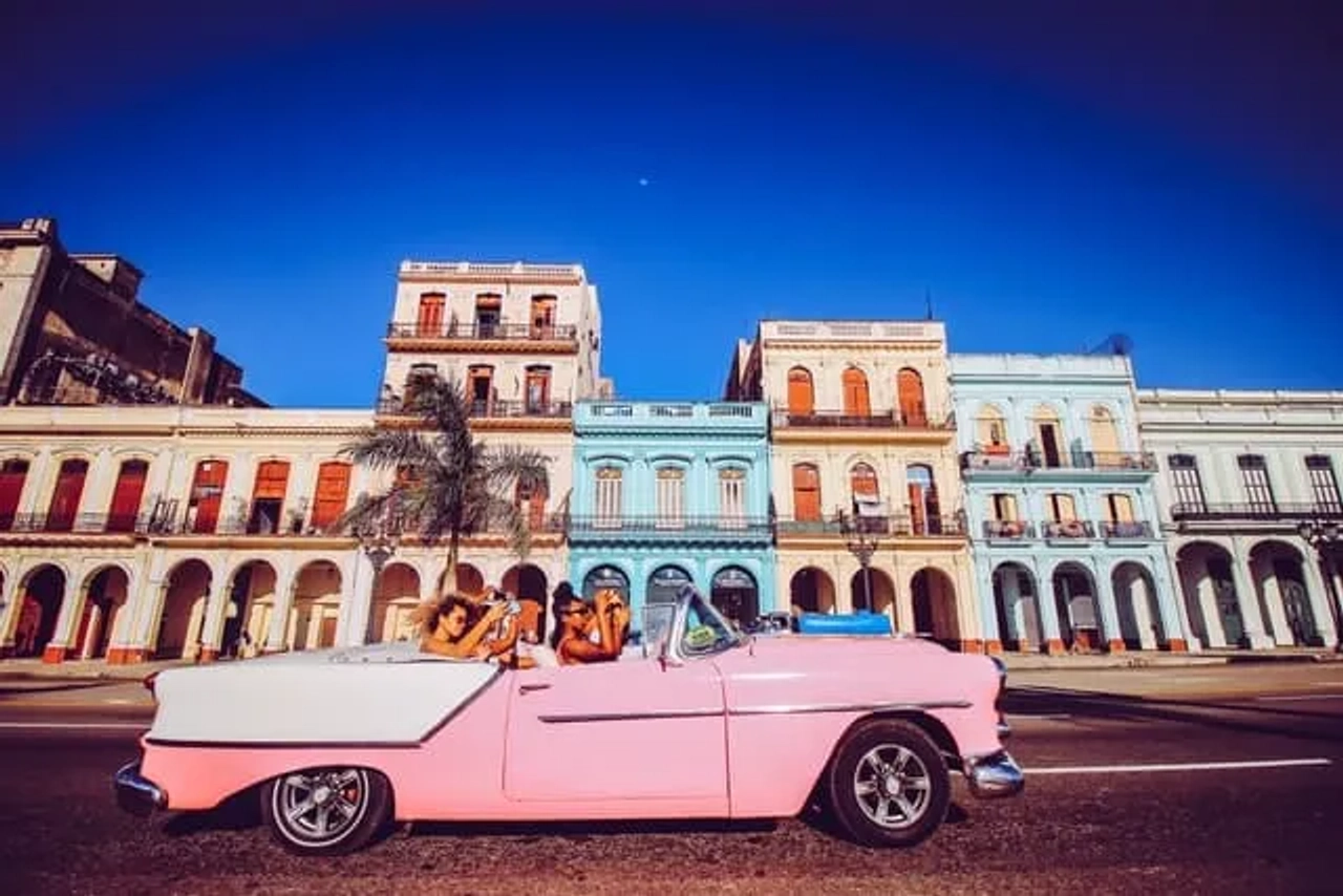carro descapotável cor de rosa numa rua em Havana