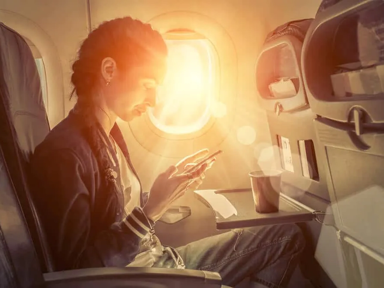 mulher a utilizar telefone no aviao
