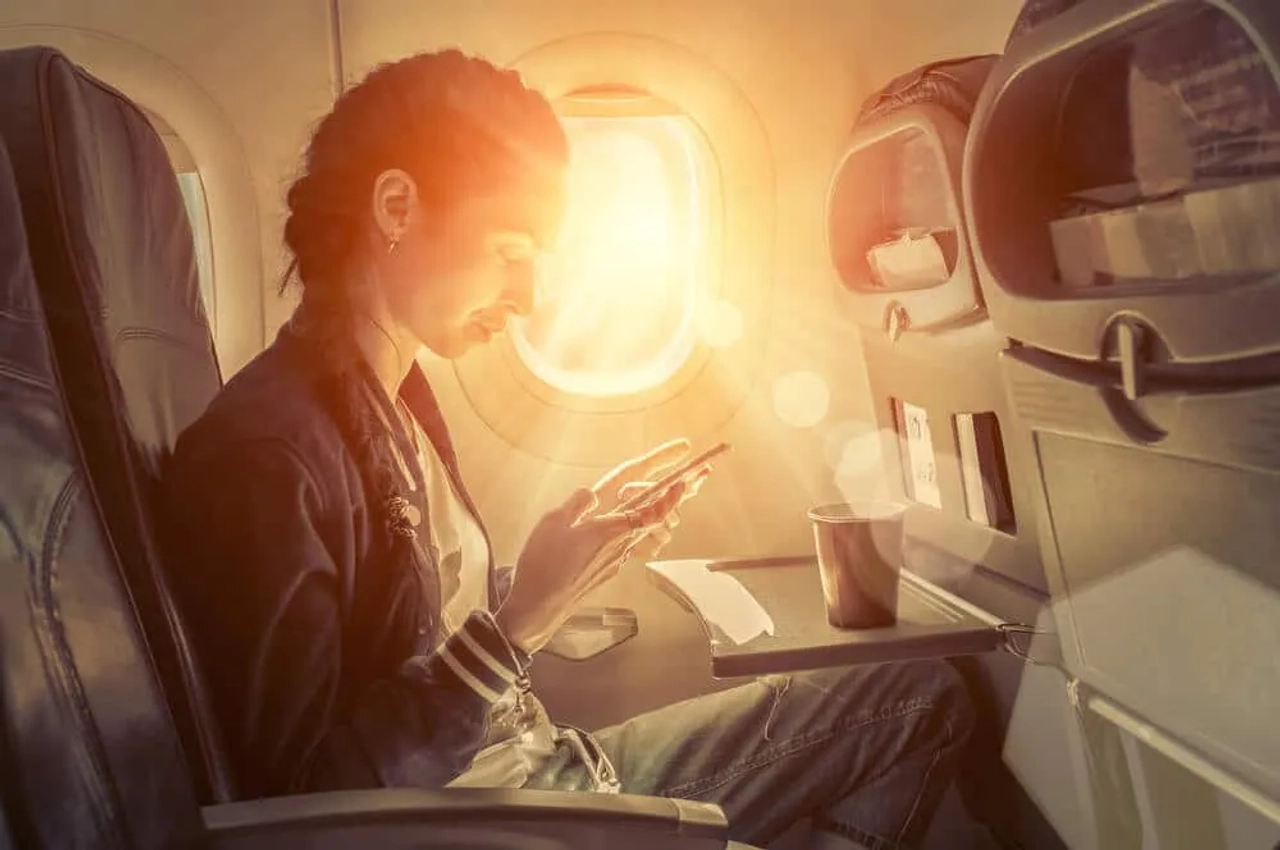 mulher a utilizar telefone no aviao