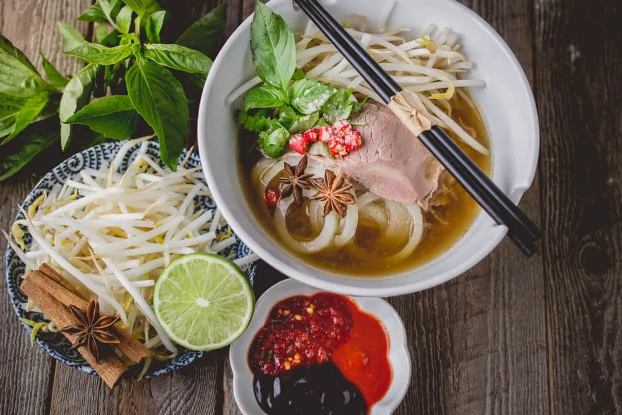 prato de sopa pho com varios ingredientes misturados