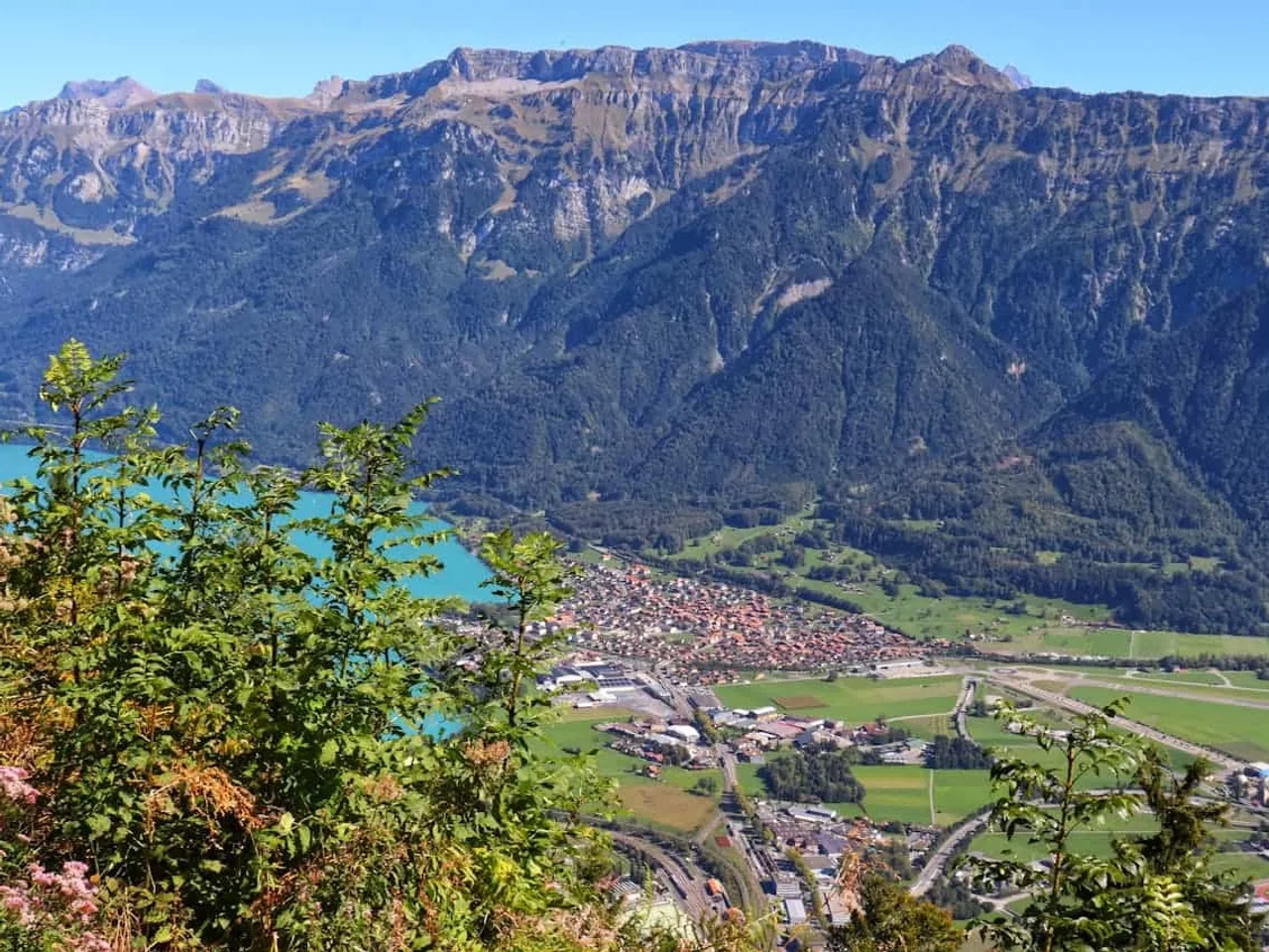 Vista panorâmica de montanhas, lago e cidade na Suíça. Natureza exuberante e paisagens alpinas.