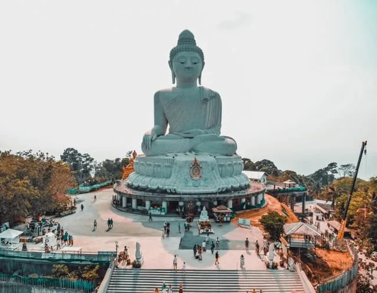 estátua de buda cinzento com pessoas à volta