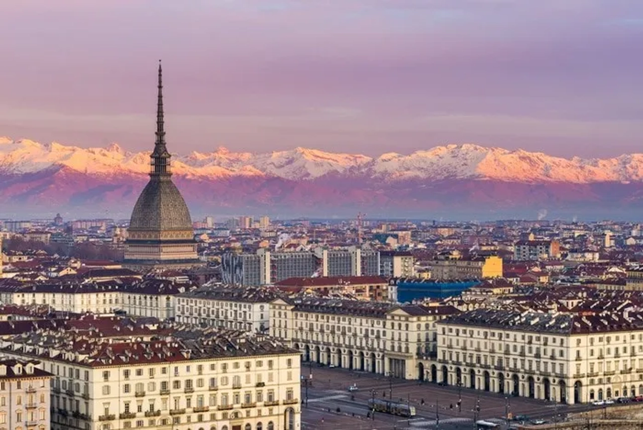 Vista panorâmica de Turim, em Itália, com a Mole Antonelliana em destaque e os Alpes ao fundo.