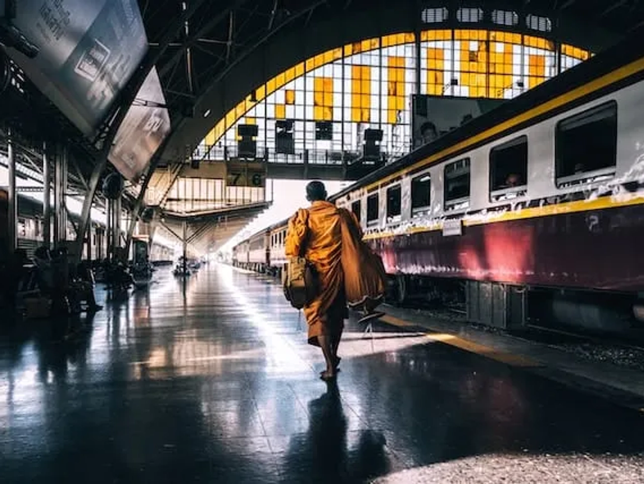 homem vestido de amarelo a caminhar para um comboio na tailandia
