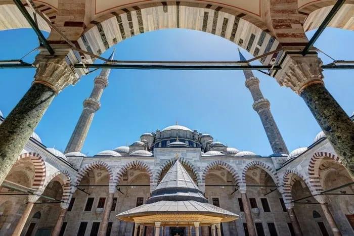 Vista interna de uma mesquita em Istambul, destacando arcos e minaretes.