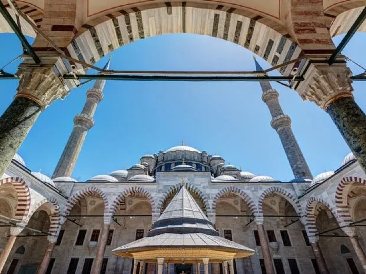 Vista interna de uma mesquita em Istambul, destacando arcos e minaretes.