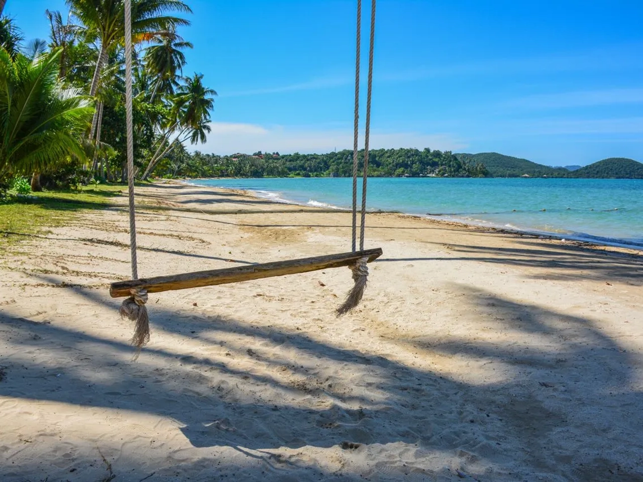 Spiaggia tropicale di Koh Samui in Thailandia con palme, altalena sulla sabbia e mare turchese.