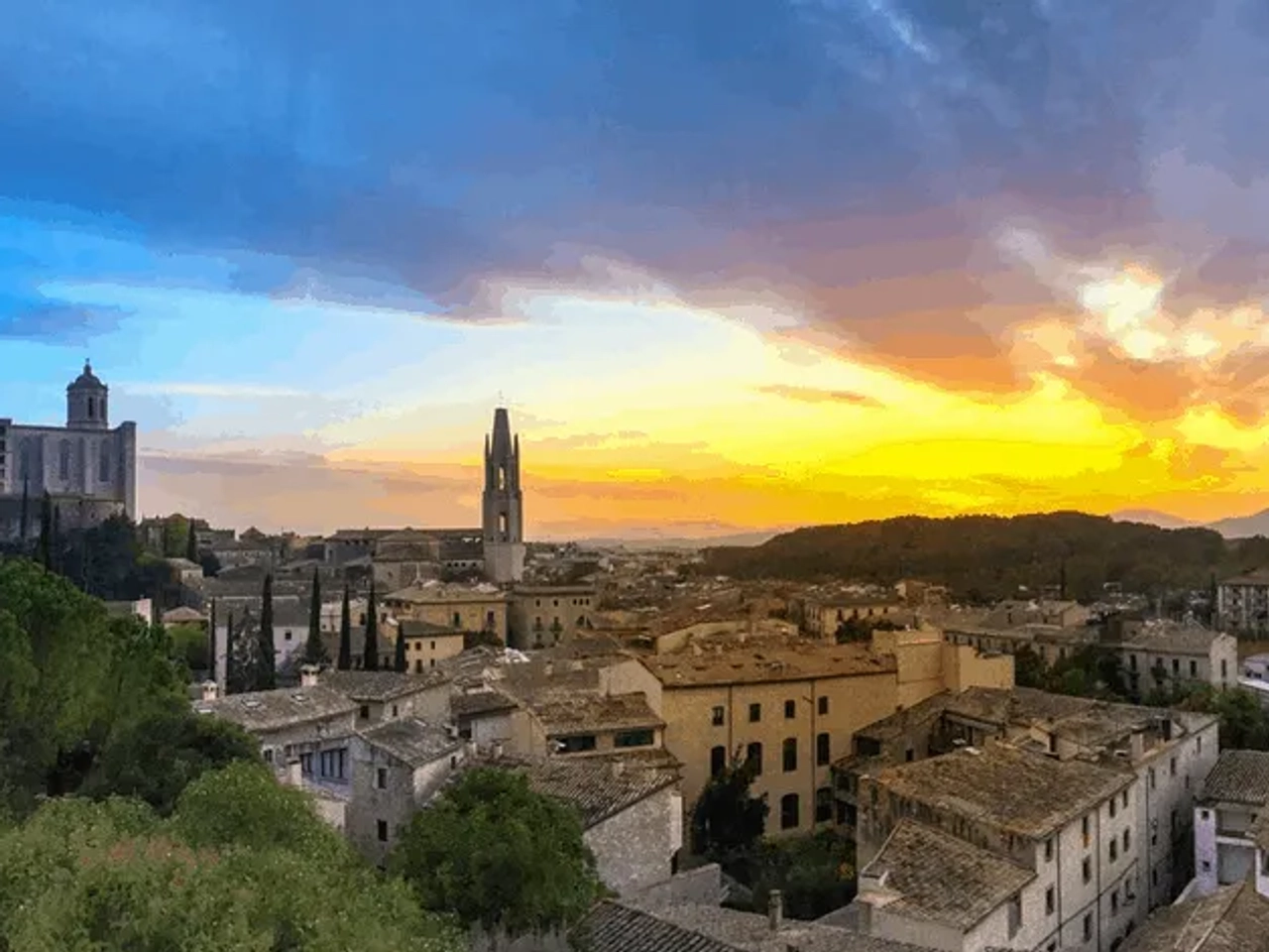 Vista panorámica de una ciudad con edificios históricos y un atardecer colorido.