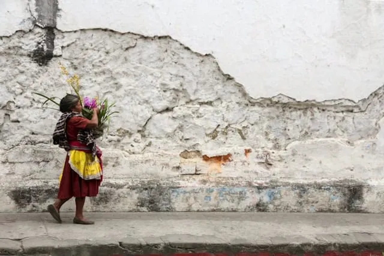 senhora a carregar um cesto colorido em guatemala