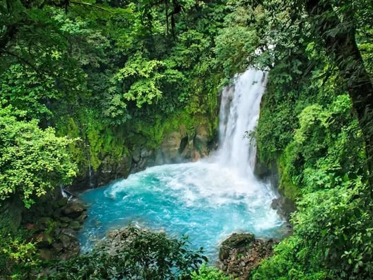 waterfall between green mountains in Volcán Tenorio, Guanacaste Province, Costa Rica