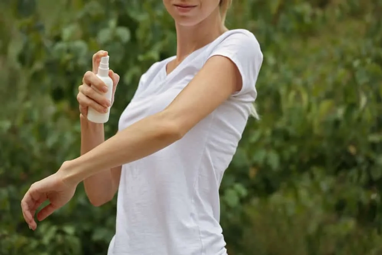 mulher a meter spray repelente de insetos nos braços