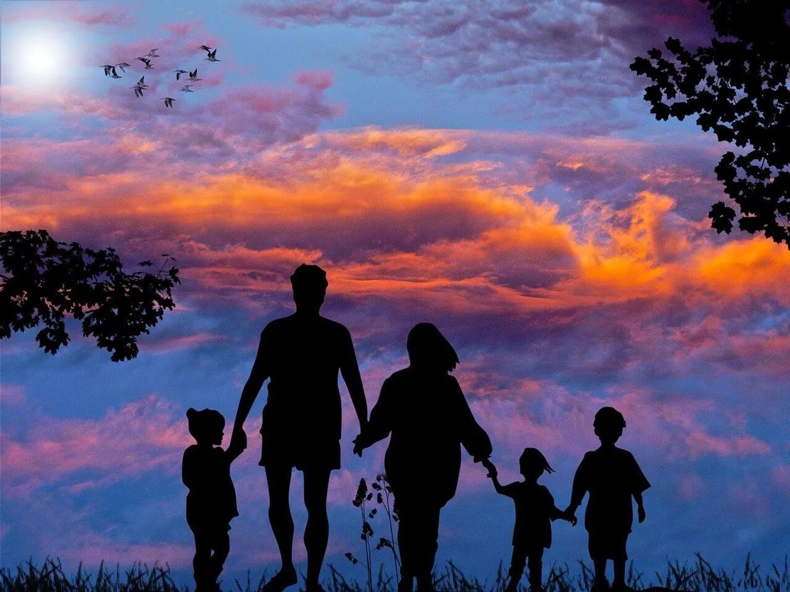 Família caminhando unida ao pôr do sol, simbolizando viagens com crianças.