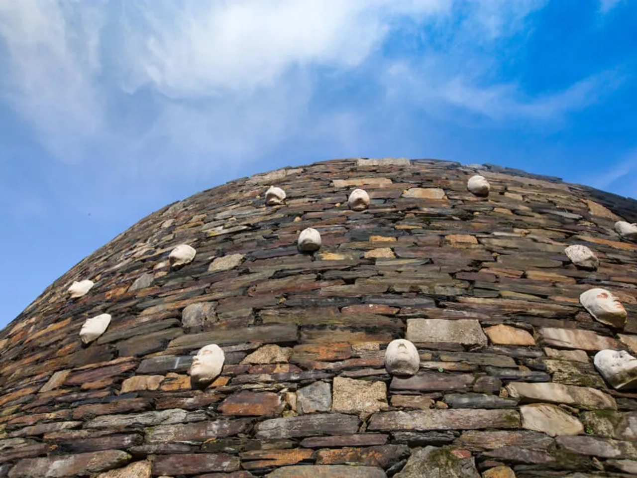 parede da quintadona com mascaras e ceu azul