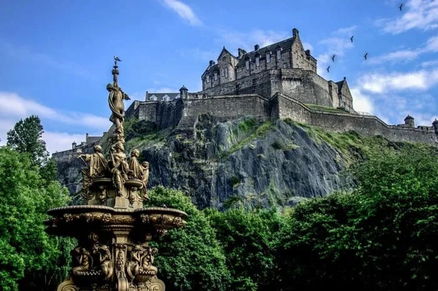 Castelo de Edimburgo ao fundo, com uma fonte ornamental em primeiro plano.