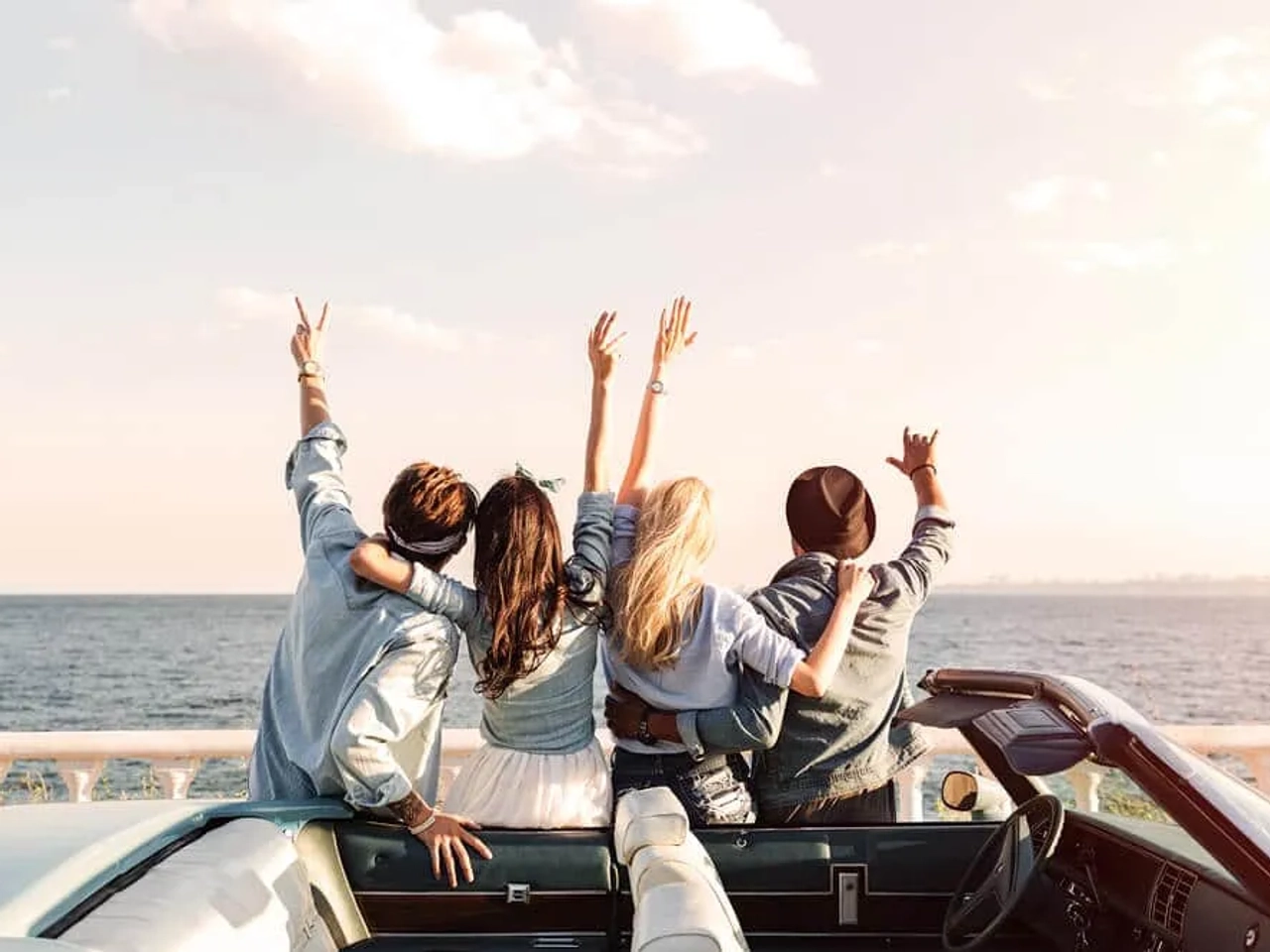 grupo de amigos de costas em frente a praia