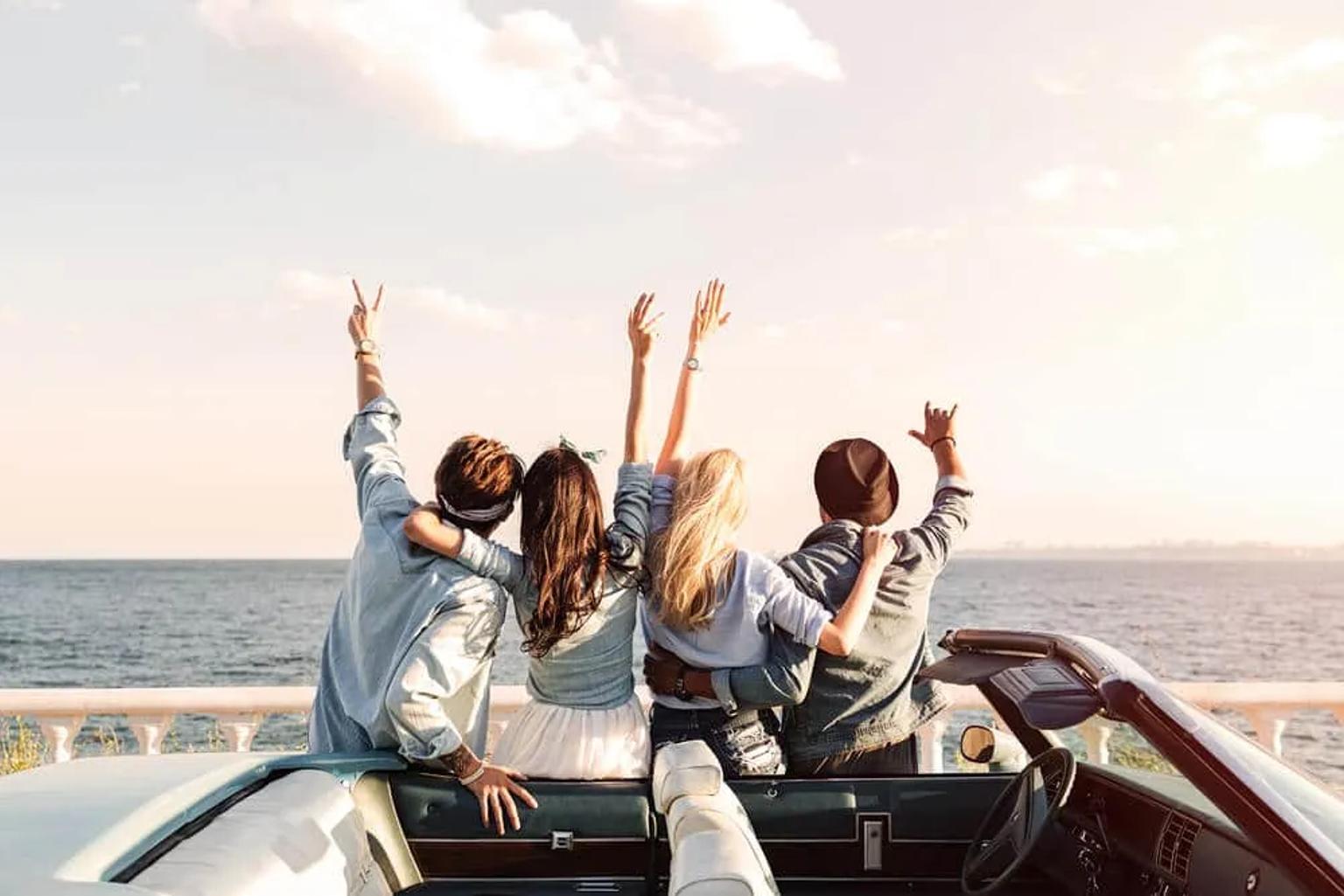 grupo de amigos de costas em frente a praia