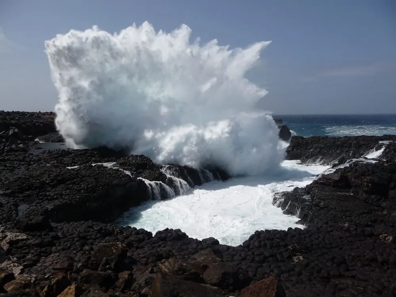 ondas rebentam contra a buracona