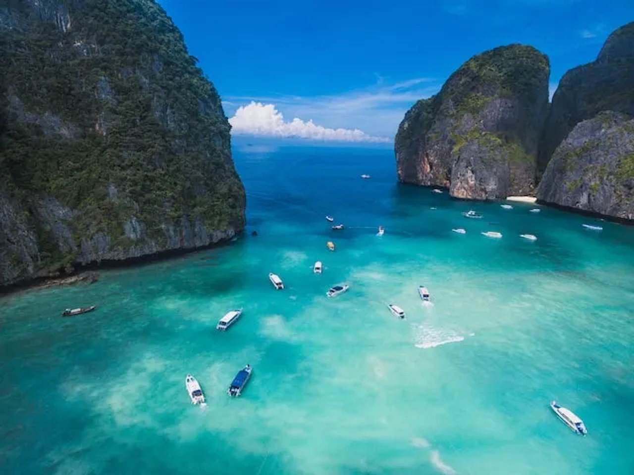many boats seen form above in crystal clear water in thailand