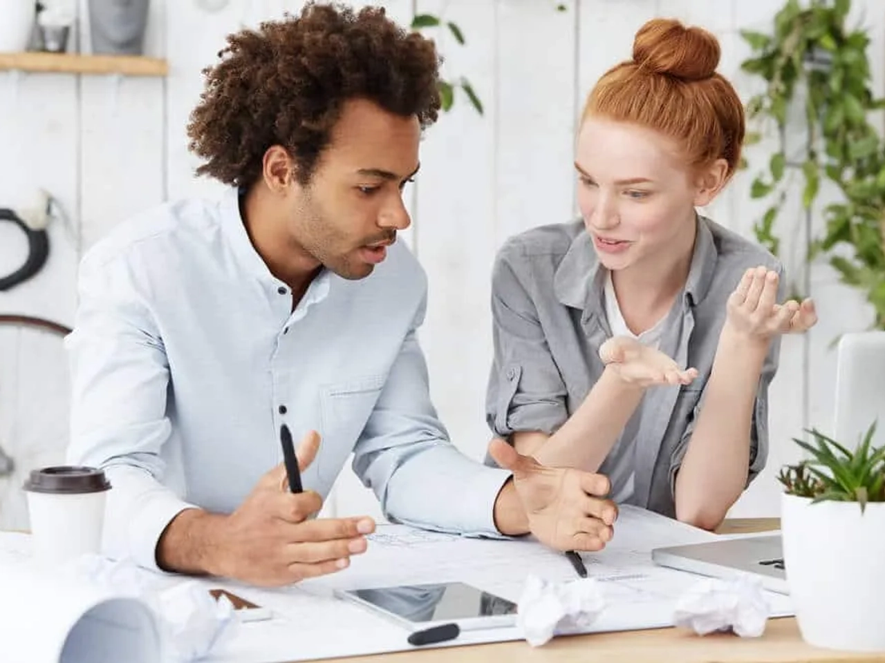 duas pessoas trabalham juntas numa mesa