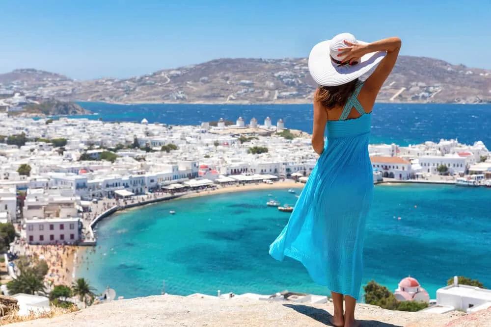 panoramica de mykonos e mulher de vestido azul