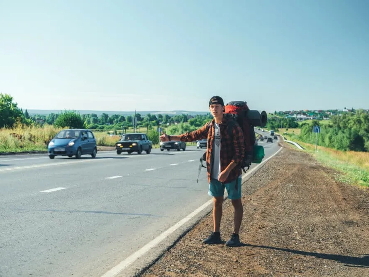 jovem com mochila de campismo pede boleia
