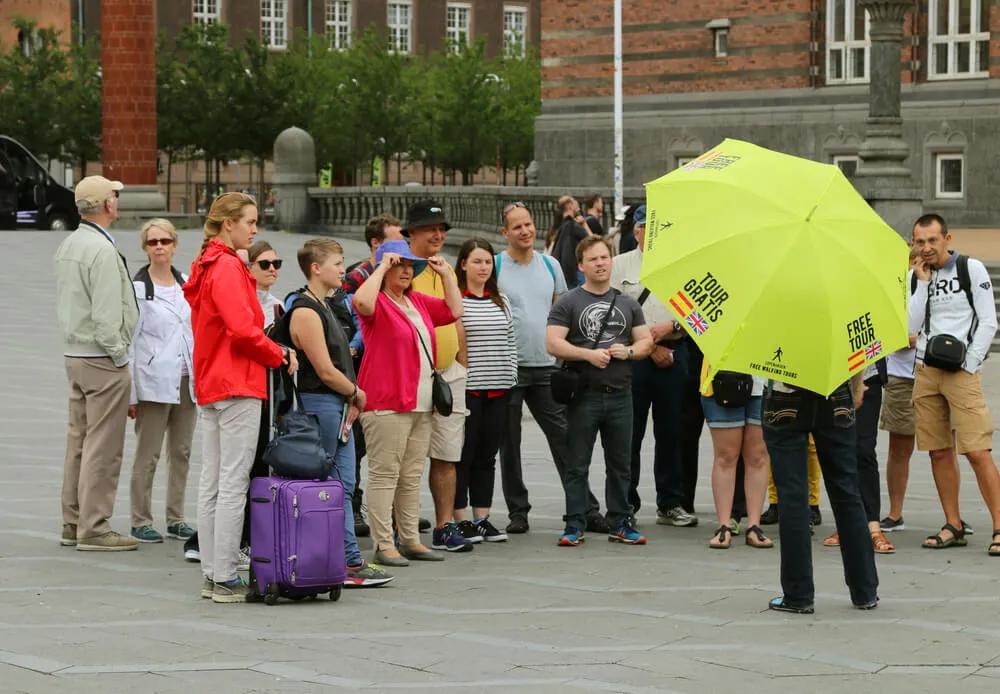 grupo de pessoas assiste às explicações de um guia freetour