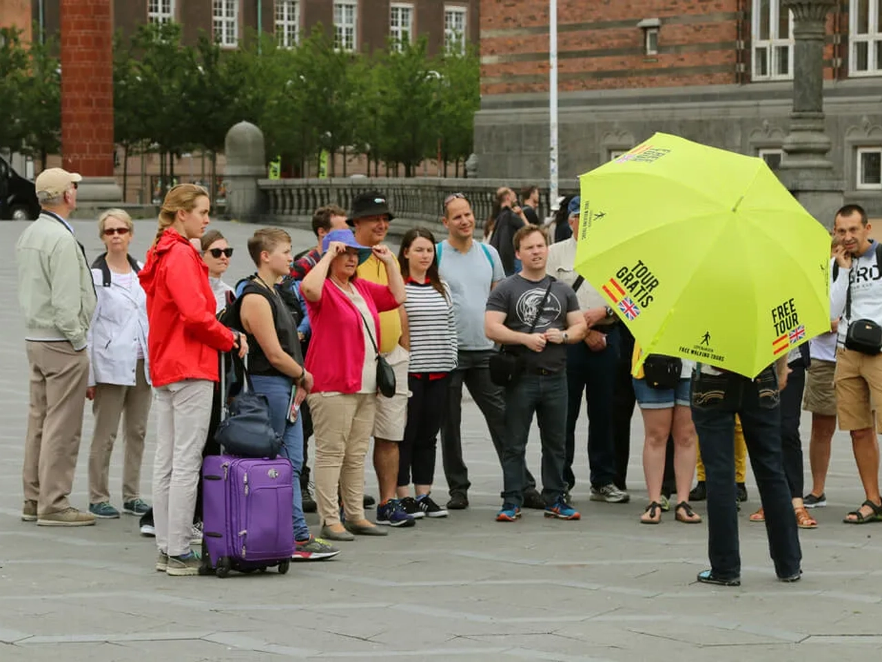 grupo de pessoas assiste às explicações de um guia freetour