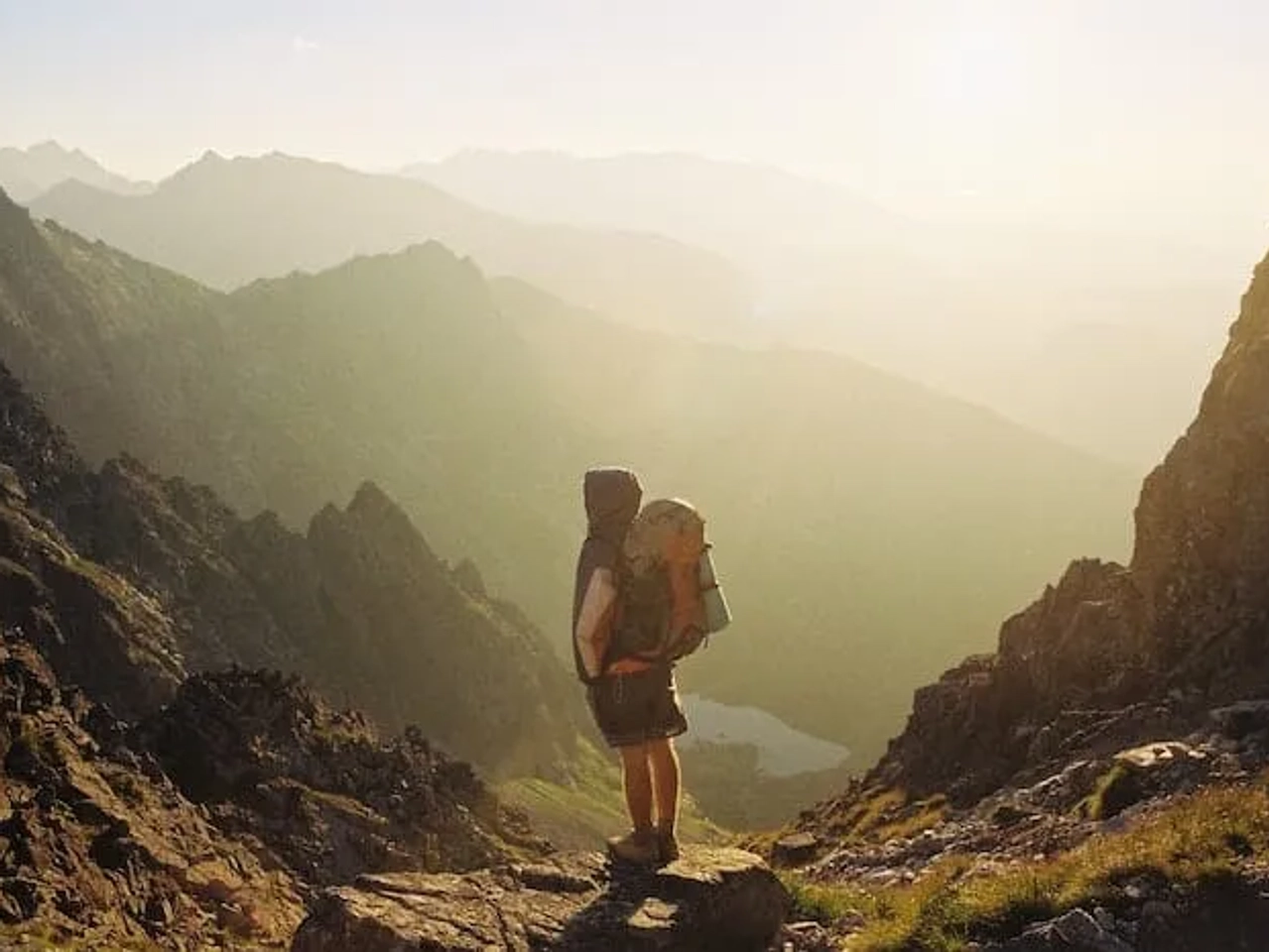 mochileiro parado em frente a montanha a observar