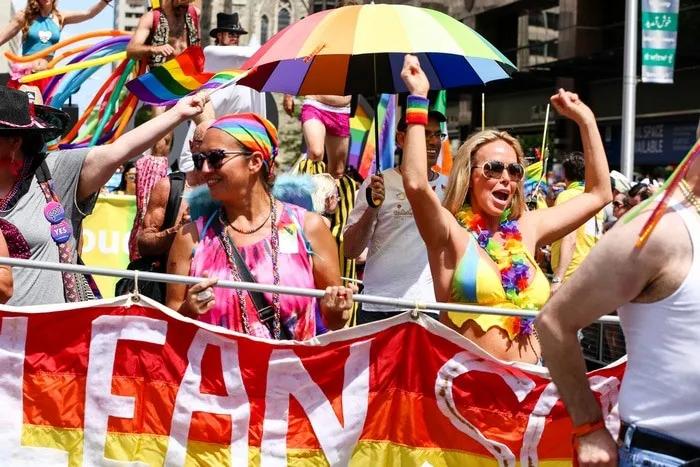 Celebración del Día del Orgullo Gay con personas vestidas coloridamente y banderas.