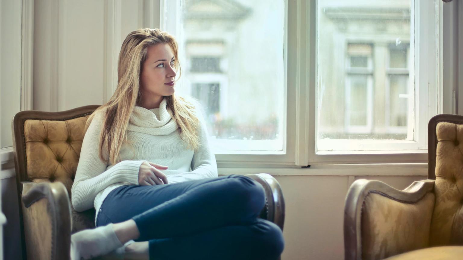 Mujer pensando en su salón para qué sirve un seguro de vida y cuándo merece la pena contratarlo.