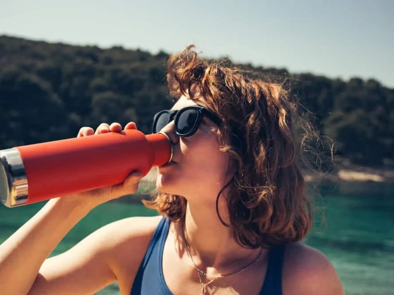 mulher a usar garrafa de aluminio