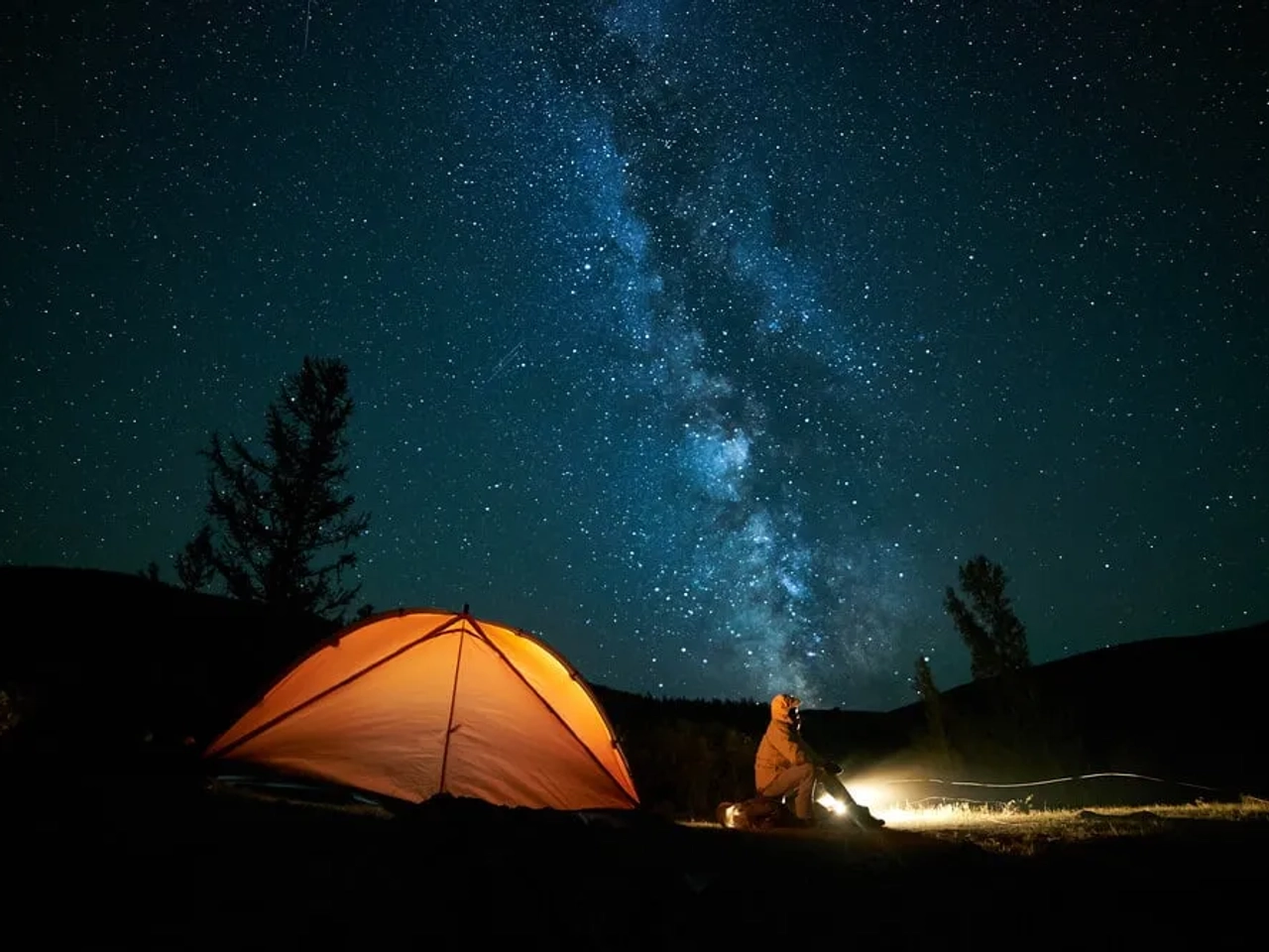 noite estrelada e tenda de campismo laranja